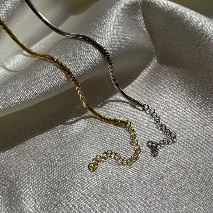 Couple wearing snake chain bracelets – gold and silver